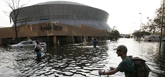 A man pushes his bicycle through flood waters near the Superdome in New Orleans on Aug. 31, 2005. Photo credit: AP Photo/Eric Gay.
