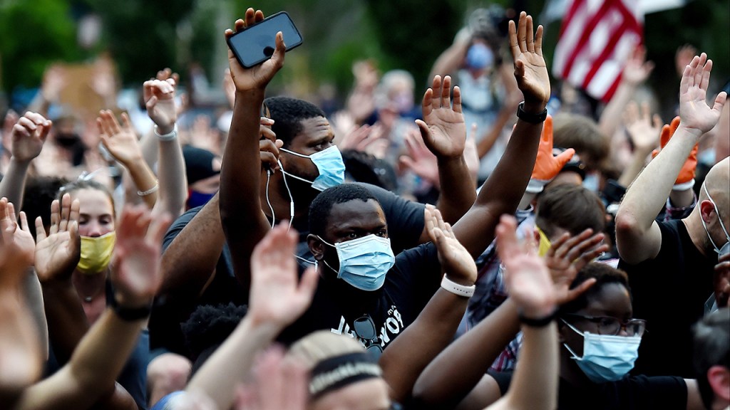 Protesters kneel and hold up their hands in Lafayette Square, near the White House, on June 4 to protest the death of George Floyd.