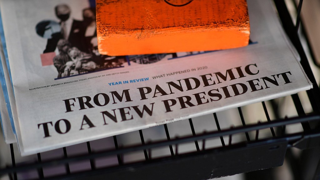 The front page headline of a newspaper states “FROM PANDEMIC TO A NEW PRESIDENT” on December 31, 2020 in Rehoboth Beach, Delaware. (Mark Makela/Getty Images)