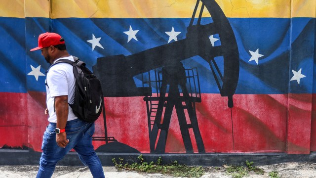 A man walks past a mural depicting an oil pumpjack in Caracas, Venezuela, on Jan. 15, 2026. U.S. President Donald Trump has recently encouraged American companies to invest in Venezuela's oil industry following the ousting of the country's leader, President Nicolás Maduro, earlier in January. (Pedro Mattey/AFP via Getty Images)