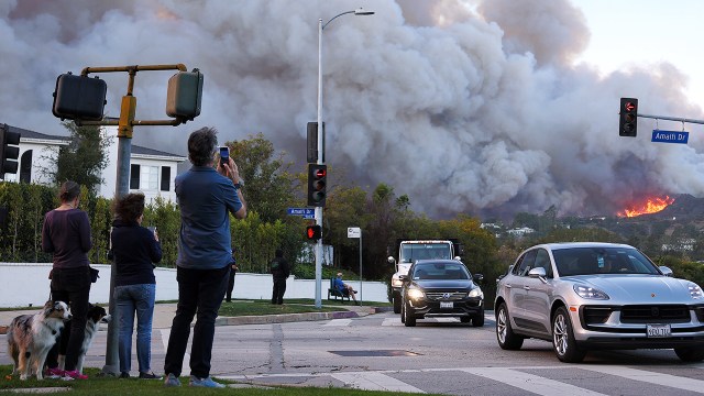 People watch as others drive away from the Palisades Fire on Jan. 7, 2025, in Pacific Palisades, California. (Mario Tama/Getty Images)
