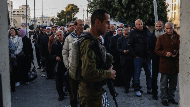 Palestinian Muslims gather at a checkpoint in the West Bank city of Bethlehem on February 20, 2026. (Hazem Bader/AFP via Getty Images)